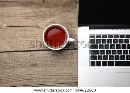 Blank business cards with pen, laptop and tea cup on wooden office table