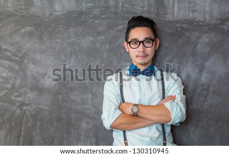 Young asian man portrait with the grunge concrete wall