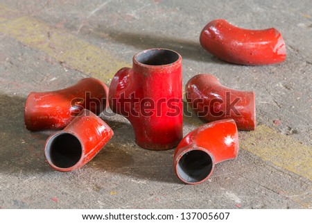 Grunge red color iron pipe joint on concrete floor