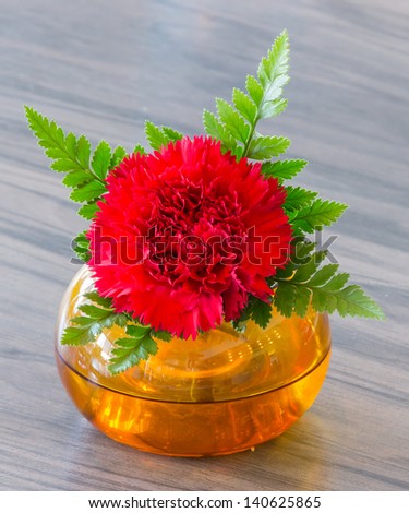 Beautiful red flower in orange vase decoration on table