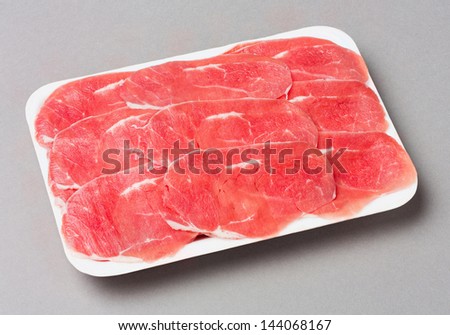 Sliced beef shank in foam tray isolated on gray background