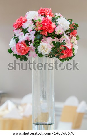 Flower bouquet in glass vase on dining table in wedding party