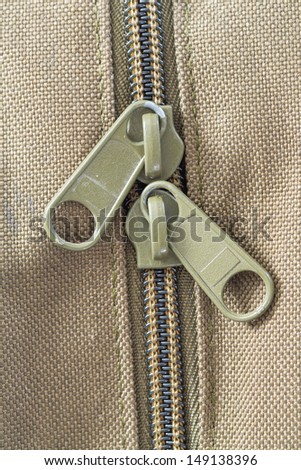 Close up green color plastic zip on brown clothes
