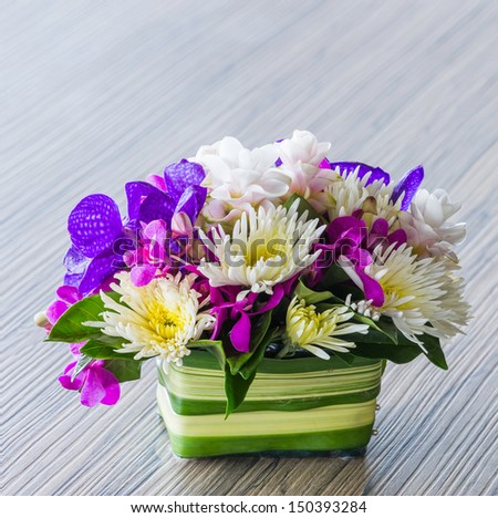 Flower bouquet of vanda, orchid, chrysanthemum on wood table