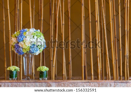 Close up  rose, hydrangea, carnation flower bouquet in glass vase and bamboo sticks background