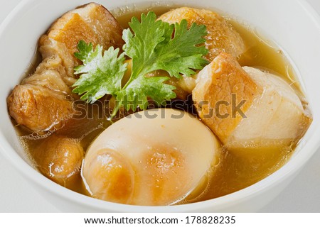 Close up Sweet pot stewed streaky pork and egg with five spices in white ceramic bowl - deep focus image