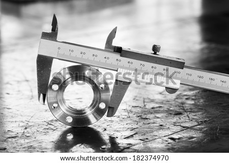 Close up vernier caliper measure diameter of stainless steel flange