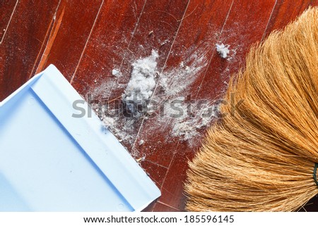 Close up dirty dust on old wooden parquet floor with broom and dustpan