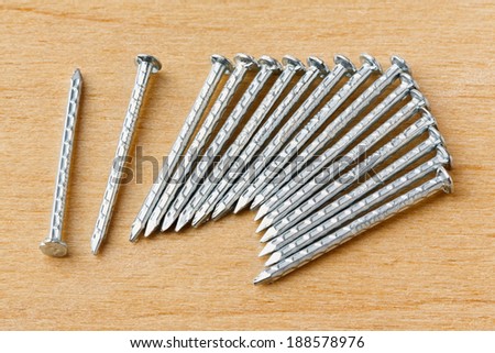 Close up galvanized iron nails for furniture fitting on plywood table - deep focus image - stacked photo