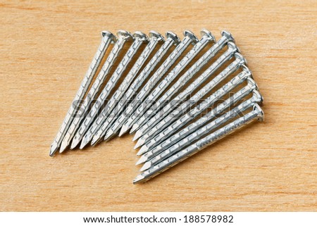 Close up galvanized iron nails for furniture fitting on plywood table - deep focus image - stacked photo