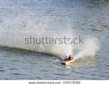 Close up radio controlled fuel engine toy boat in lake