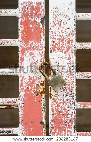 Close up old and dirty door and rusty pad lock