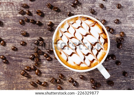 Close up one Cup of coffee and roasted bean on old wooden table