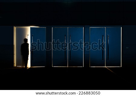 Door opened with motion blur of a man and light coming through the space
