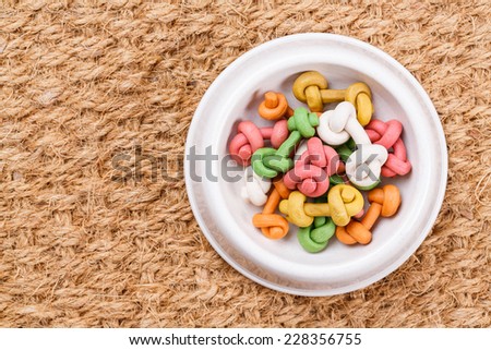 Close up cat or dog food snack in plastic bowl on Coconut fiber doormat