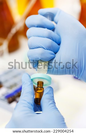 Close up scientist using nylon syringe filter in laboratory