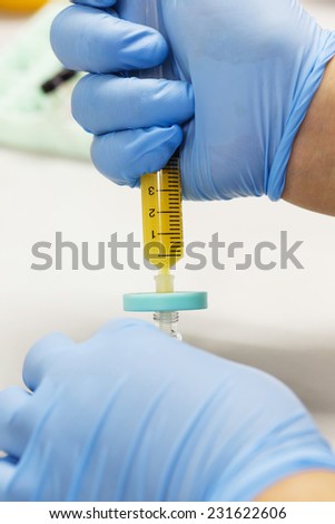 Close up scientist using nylon syringe filter in laboratory
