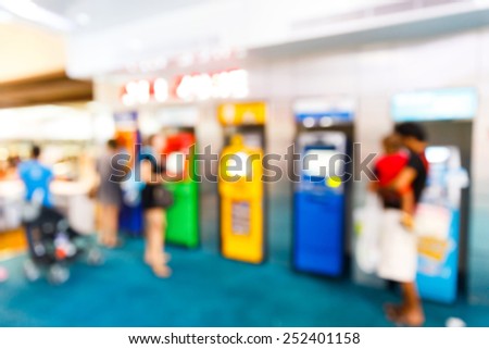 Abstract Blurry people with automatic teller machine or ATM in shopping centre