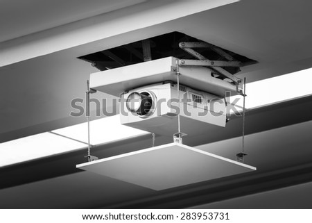 Old and dirty projector hang on ceiling in meeting room, education concept
