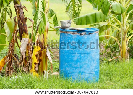 Old plastic barrel container used as water tank in farmland