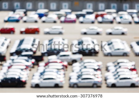 Abstract blurred new cars in parking lot waiting to export via ship, overseas vehicle shipping