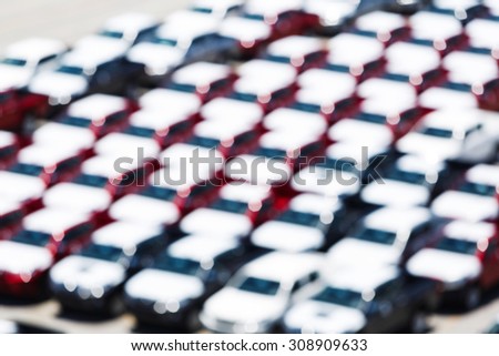 Abstract blurred new cars in parking lot waiting to export via ship, overseas vehicle shipping