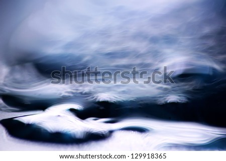 Bizarre waves and swirls. macro shot of blue liquid soap and water