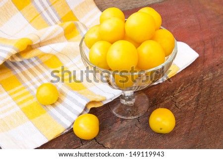 ripe yellow plums on a wooden background