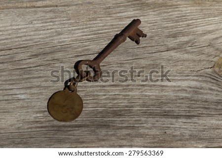 Antique old rusty sanitarium skeleton key / hospital key on a rustic wood background