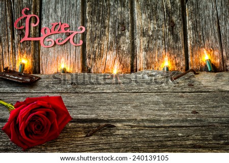 Red Rose with the Word Love on Rustic Old Barn Wood with Lights