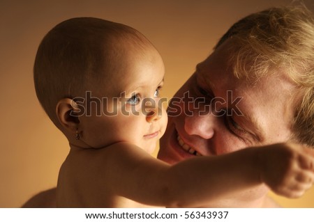 stock photo The little naked happy girl with her father on dark background