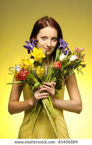 Portrait of cute  girl in yellow dress with a bunch of flowers
