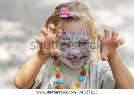 Little girl with painted face as a cat