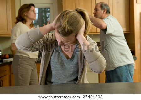 Teenage daughter covers ears during family argument