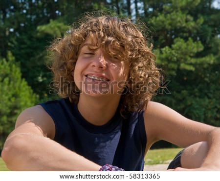stock photo : handsome boy with long curly hair (and braces) making a face