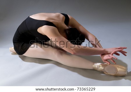 Young ballet dancer, posing, stretching in studio