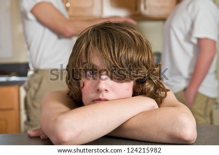 Young boy, age 12, crying (or about to cry) during family argument