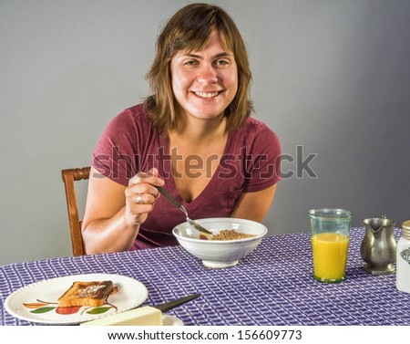 Young woman enjoying gluten-free breakfast - flax cereal and gluten free toast