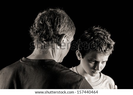 moody monochrome portrait of father-son trouble: father tries to reason with (or scold, or comfort) his defiant son