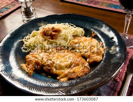A serving of Chicken Parmesan (Chicken Parmigiana) with angel hair pasta