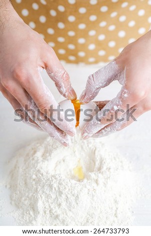 Flour and eggs. Hands kneading dough on board