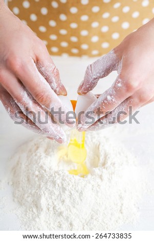 Flour and eggs. Hands kneading dough on board