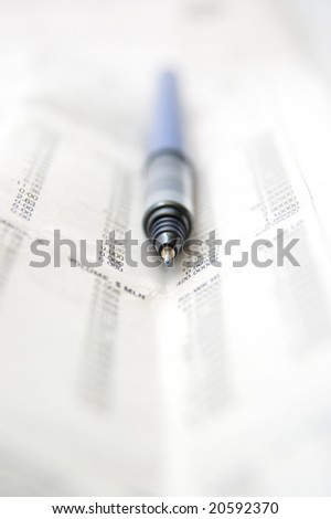 Pen and newspaper.Pen in focus
