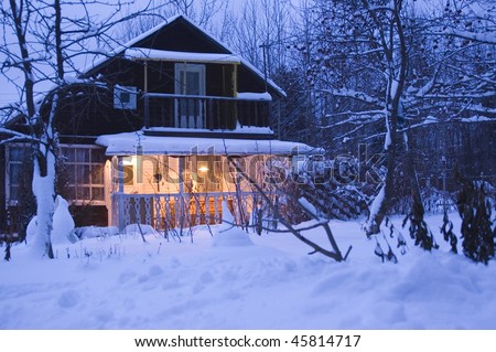 Wooden house in dark winter forest