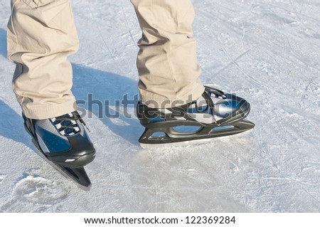 Men\'s feet in ice skating rink