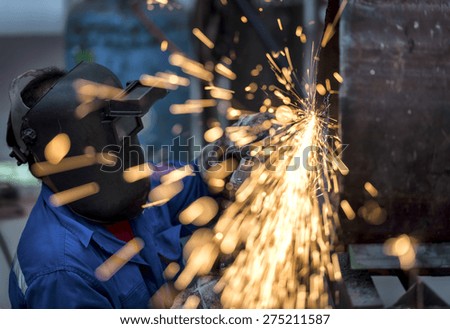 Electric wheel grinding on steel pipe in factory