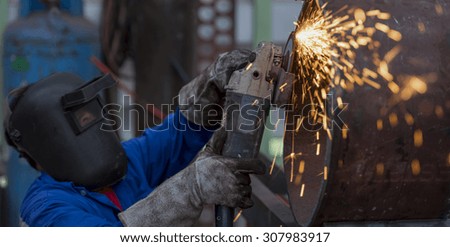 Electric wheel grinding on steel pipe in factory (Focus on Tool)