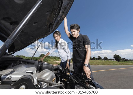 Man and woman stand by the broken car and don\'t know what to do
