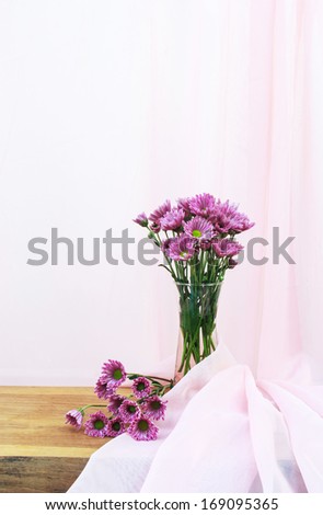 Romantic  a bouquet of Chrysanthemum purple  in glass  jug  on wooden table  and pink cloth background