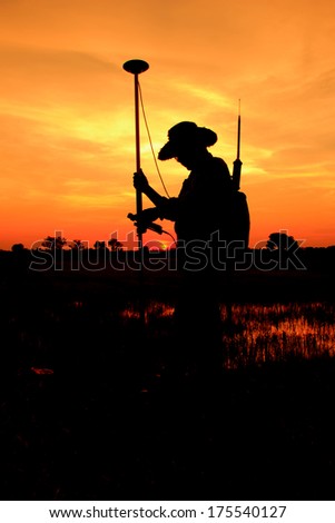 Silhouette of Surveyor worker make data collection with GPS surveying in  field,